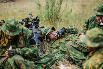Fototapeta premium soldiers team are heated food on the fire and eat in the forest