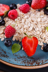Muesli with fresh berries and hone, on the blue plates Healthy Breakfast.selective focus