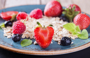 Muesli with fresh berries and hone, on the blue plates Healthy Breakfast.selective focus