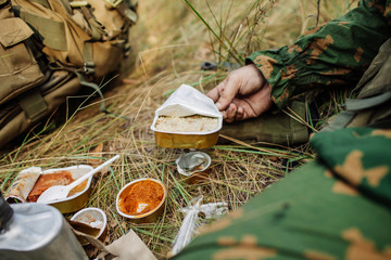 soldiers team are heated food on the fire and eat in the forest
