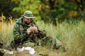 soldiers team are heated food on the fire and eat in the forest
