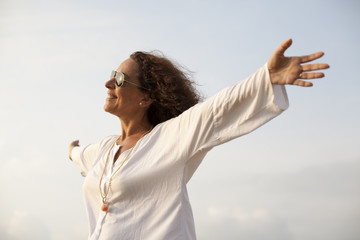 Mujer con los brazos abiertos hacia el sol