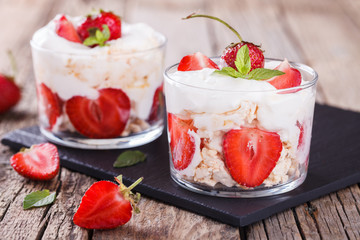 Eton Mess - Strawberries with whipped cream and meringue in a glass beaker. Classic British summer dessert.selective focus