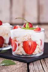 Eton Mess - Strawberries with whipped cream and meringue in a glass beaker. Classic British summer dessert.selective focus