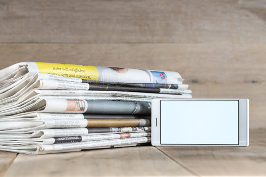smartphone template and stack of newspapers displaying current i
