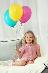 Fototapeta na wymiar Little girl with balloons in the room