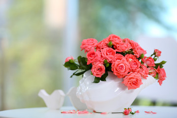 Beautiful rose in vase on table in room