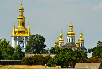 Fototapeta na wymiar Belfry and church of Kiev Pechersk Lavra in front of blue sky