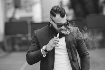 man with a beard smokes electronic cigarette