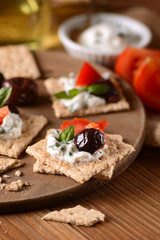 spuntino con formaggio alle erbe, olive e pomodoro