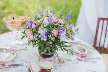 Served table outdoors. Flower arrangement with lavender and