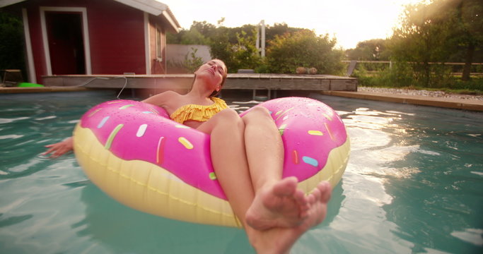 Teenage Girl floating in swimming pool