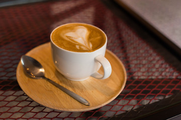 Hot art Latte Coffee in a cup on wooden table.