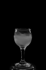 Smoke shisha in cocktail glass on a black background.