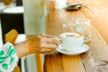Female hand holding cup of coffee