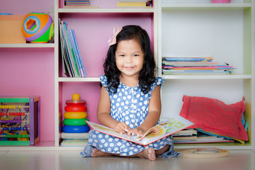 Child read, cute little girl is smiling and reading a book