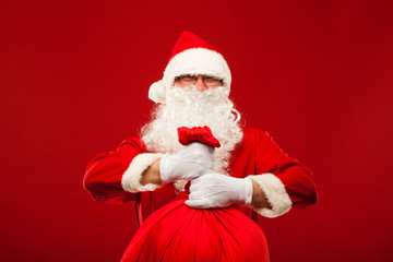 santa claus with big bag on shoulder glasses  red background