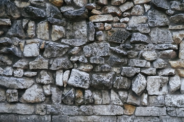 Texture of gray rough granite stone wall