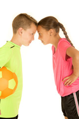 Funny portrait of a boy and girl in soccer uniforms leaning touc