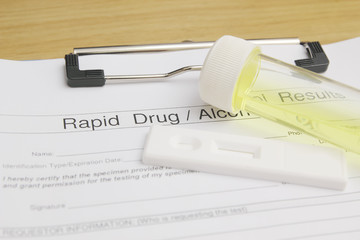 Drug test blank form with test kit and urine,focus on paper