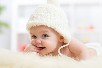 Cute little baby looking into the camera and weared in white hat