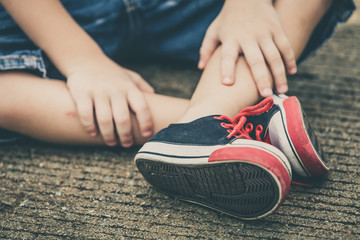 youth sneakers on boy legs on road
