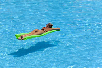 Beautiful blonde woman relaxing in a swimming pool