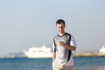 Young man using mobile phone at sea