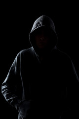 Fototapeta na wymiar Faceless guy in hoodie in the darkness