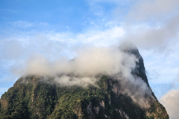 Top of mountains covered by clouds and fog in the morning of the sunny day.