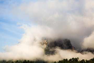 islands and mountains covered by clouds and fog in the morning of the sunny day in warm tone.