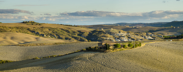 Naklejka premium Farmers villas scattered on the Tuscan fields