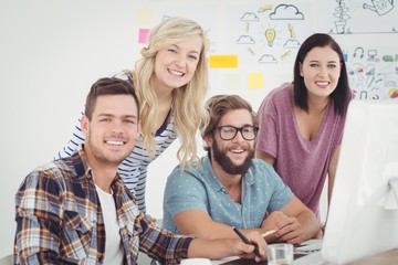 Portrait of cheerful business team working on a computer