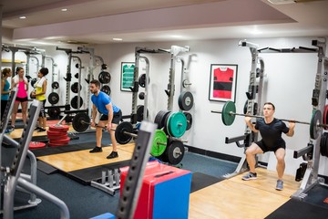 Fototapeta na wymiar Fit people working out in weights room