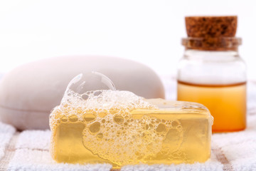 Fototapeta na wymiar Herbal spa soap bar on white bath towel with honey isolate on wh