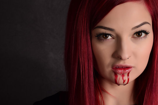Vampire woman with blood on her face and red hair