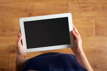 girl holds tablet on wooden background