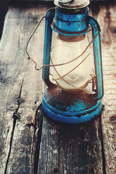 Vintage Dirty Blue Oil lantern on Wooden Background