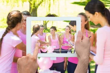 Composite image of hand holding tablet pc