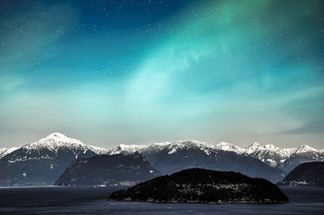 Northern lights aurora borealis in the night sky over beautiful lake landscape