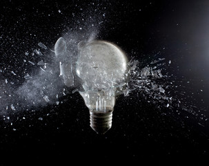 explosion glass bulb filament black background. fragility obsolete creativity