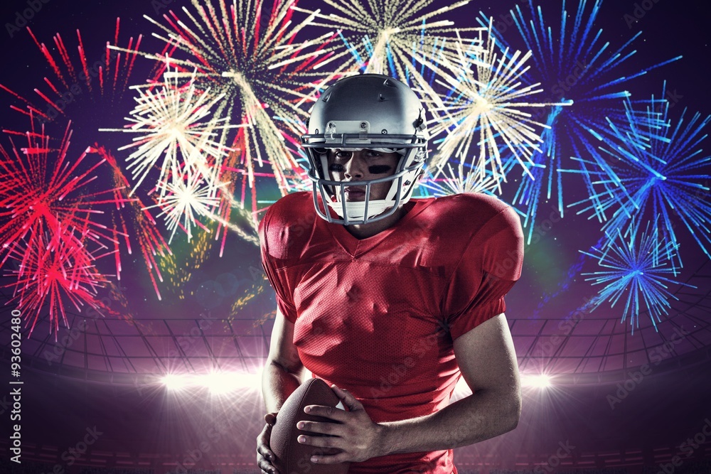 Wall mural American football player holding ball against fireworks