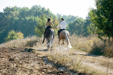 Young couple in love riding a horse