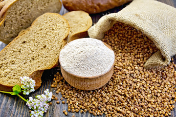 Flour buckwheat in bowl with grains on board