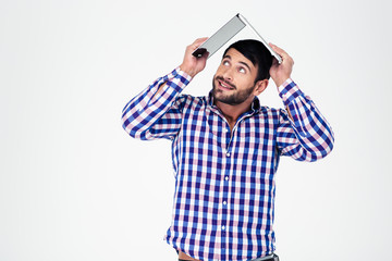 Man holding laptop on his head like roof of house