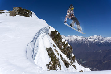 Flying snowboarder on mountains