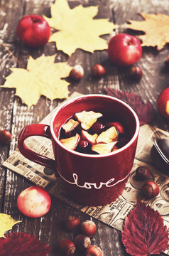 Tea with apple and cranberry and yellow autumn leaves