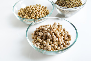 Pile of Chickpeas in bowl and other Legumes on white