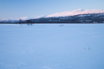 Fototapeta na wymiar Abendstimmung über einem zugefrorenen See in Schweden