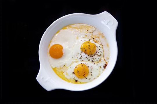 Delicious fried eggs in a porcelain pan